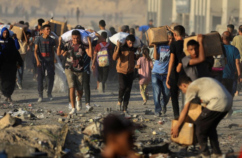 Palestinians carry aid supplies in Beit Lahiya, in the northern Gaza Strip, June 16, 2025; illustrative.