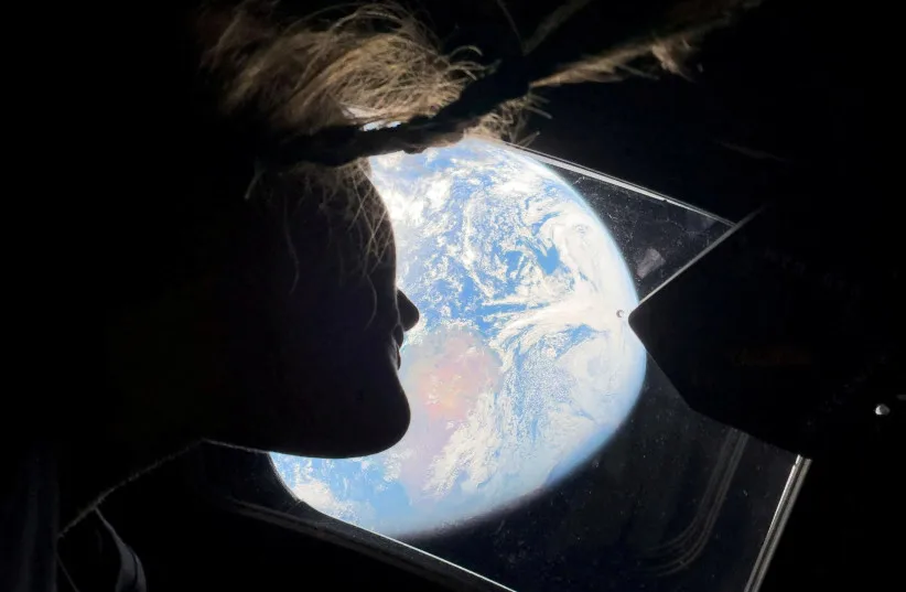 NASA ASTRONAUT and Artemis II mission specialist Christina Koch peers out of one of the Orion spacecraft's main cabin windows, looking back at Earth, as the crew travels towards the Moon April 2, 2026.