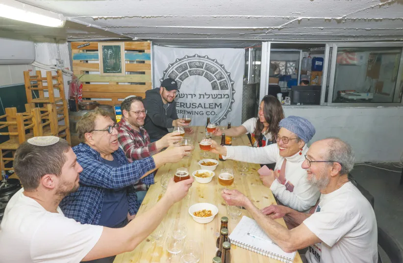 The Israel Brews and Views Tasting Team (in white shirts) raise a toast for success with the Jerusalem Brewing Co. owners, in Talpiot.