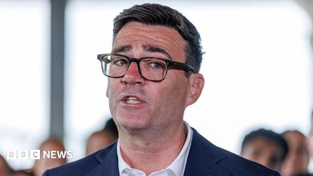 Andy Burnham in a suit and glasses. A close up of his face.