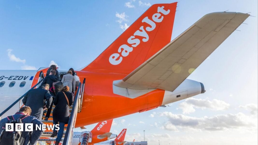 People climb steps onto an easyJet plane.