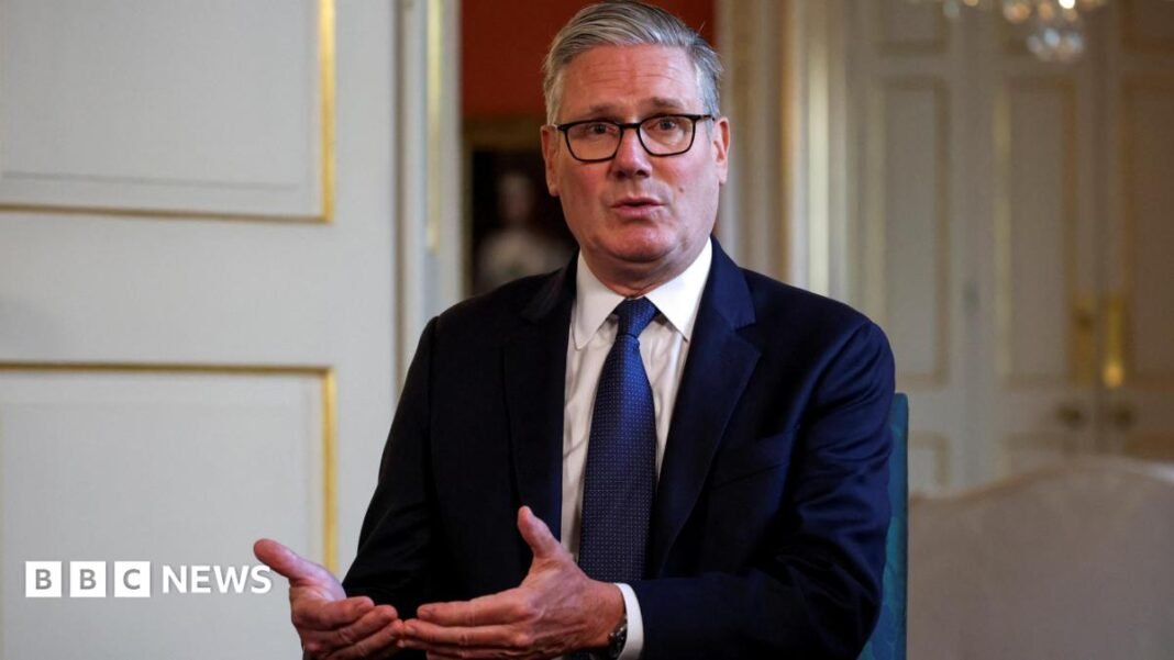 Keir Starmer wearing a dark suit and blue tie